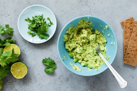 Guacamole, eine Avocadopaste mit 3 Körnern Chrupak Knäckebrot